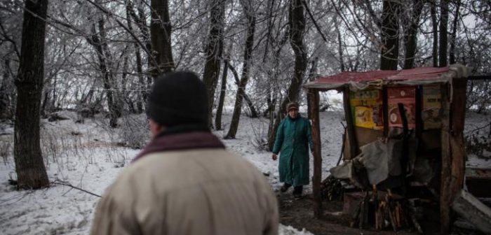 Una mujer junto a su cocina improvisada cerca de la línea del frente de Donetsk © Manu Brabo