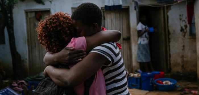 Una trabajadora de salud comunitaria de MSF, que también es trabajadora sexual, es recibida con un fuerte abrazo por una de las trabajadoras sexuales, detrás de un bar en la ciudad de Mwanza, donde las trabajadoras sexuales alquilan habitaciones para brindar servicios. Isabel Corthier/MSF