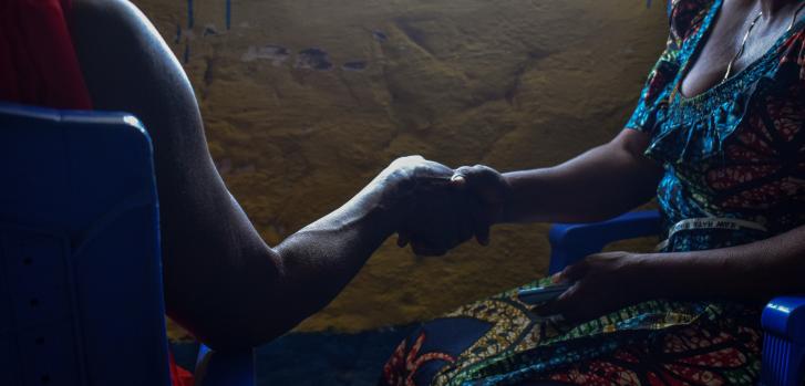 Imagen de archivo del 18 de diciembre de 2021: una paciente víctima de violencia sexual en Salamabila se encuentra junto a una integrante de su familia que sostiene su mano.Norah Mbadu/MSF.