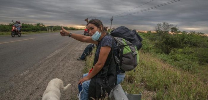 Imagen de archivo del 4 de marzo de 2022: una migrante de 34 años de Venezuela, acompañada de su perro, en Tumbes, Perú. Ella caminó desde Aguas Verdes, a 15 kilómetros en la Carretera Panamericana.Max Cabello Orcasitas.