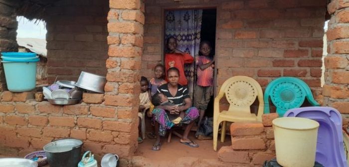 Diane y sus 5 hijos posan orgullosos delante de su casa, hecha por ellos mismos con ladrillos de barro, dentro del campo para personas desplazadas internamente de Pk3, en Bria, República Centroafricana. 
La familia huyó de la violencia en 2016.Laora Vigourt/MSF.