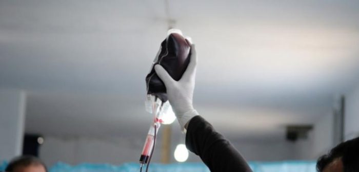Julio de 2013: Un trabajador médico sostiene una bolsa de sangre en la sala de urgencias de un hospital improvisado en Siria, que MSF creó a partir de una granja en la provincia de Idlib, en el noreste de Siria.Robin Meldrum/MSF