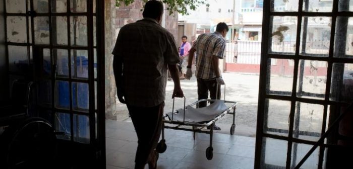 Dos hombre de Yemen sacan una camilla del hospital Al Salam para ir a recoger a un paciente a Qataba, Yemen. Julio 2015.MSF