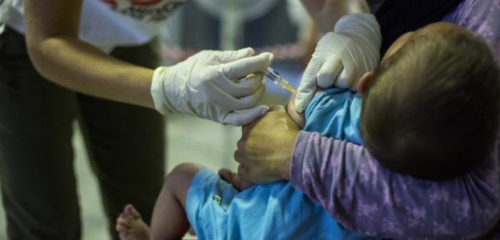 Un niño siendo vacunado por un integrante de MSF en Grecia. ©Pierre-Yves Bernard/MSF