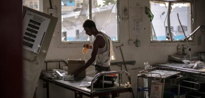 Un trabajador del hospital de Abs, en Yemen, busca medicamentos y material médico a salvo, un día después del ataque aéreo por parte de la coalición liderada por Arabia Saudí. El bombardeo se cobró la vida de 19 personas y 24 resultaron heridas. ©Rawan Shaif