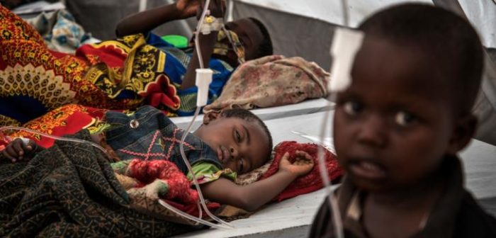 En el Centro de Tratamiento del Cólera en Minova, las filas de camas están llenas de niños recostados o sentados solos mientras sus madres entran y salen de la carpa; algunas lavan la ropa, otras tratan de alentar a sus hijos a tomar agua. © Arjun Claire