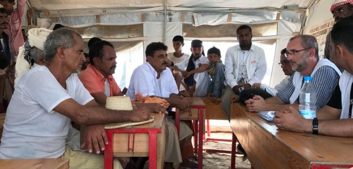 David Noguera, presidente de MSF (a la derecha), durante un encuentro con varias personas del campo de desplazados cercano a Abs, en Yemen. ©Sonia Verma/MSF