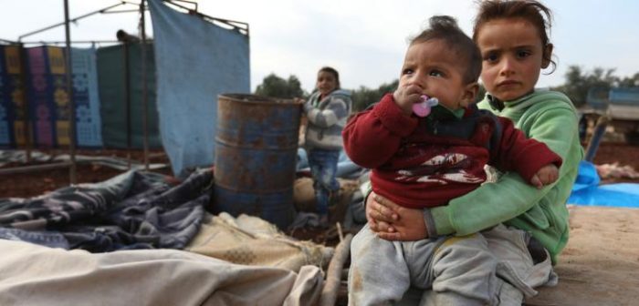 Acaban de llegar a su nueva casa, esa "carpa" que se ve de fondo. Huyen de los combates en el noreste de Siria. La ropa que llevan puesta es la única que tienen y es invierno. No tienen acceso a agua limpia, beben de ese barril oxidado. ©MSF