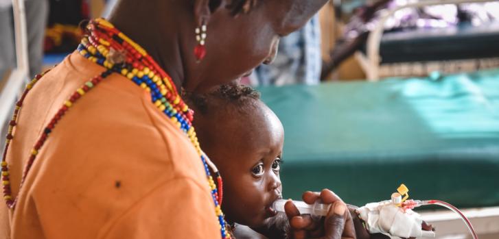 Guone Arbollo alimenta a Egura, su hija de nueve meses, con leche mediante una jeringa en el Centro de Salud de Illeret, Kenia. Egura sufre de severa malnutrición.
MSF/Lucy Makori.