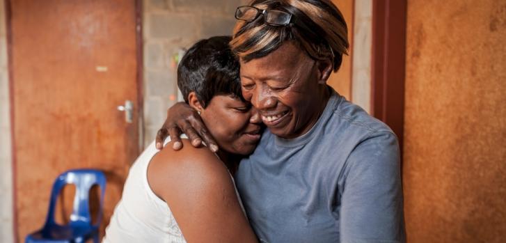 La cuidadora comunitaria Nonhlanhla Ngema en Sudáfrica abraza a un miembro de su grupo con VIH positivo.
.Greg Lomas/MSF