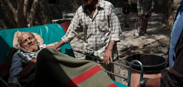 Qassim, de 83 años, originario de Radfan, a las afueras del departamento para pacientes hospitalizados del Hospital Al-Nasser Hospital, con uno de sus cuñados. Ad Dhale, Yemen 2018.Matteo Bastianelli