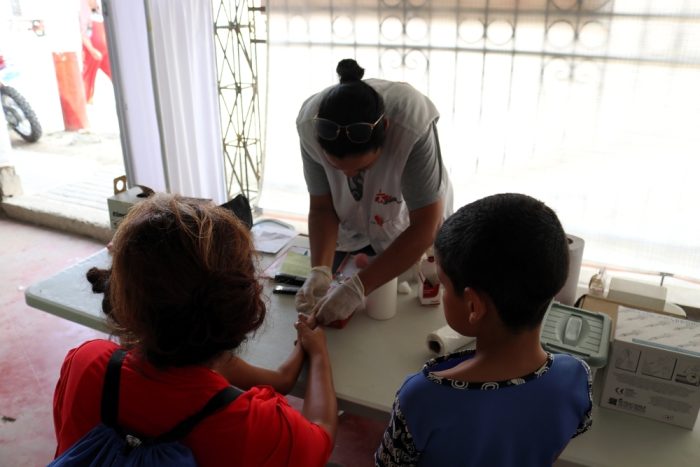 Personal de enfermería de MSF vacuna a una niña migrante en Tumbes, Perú.